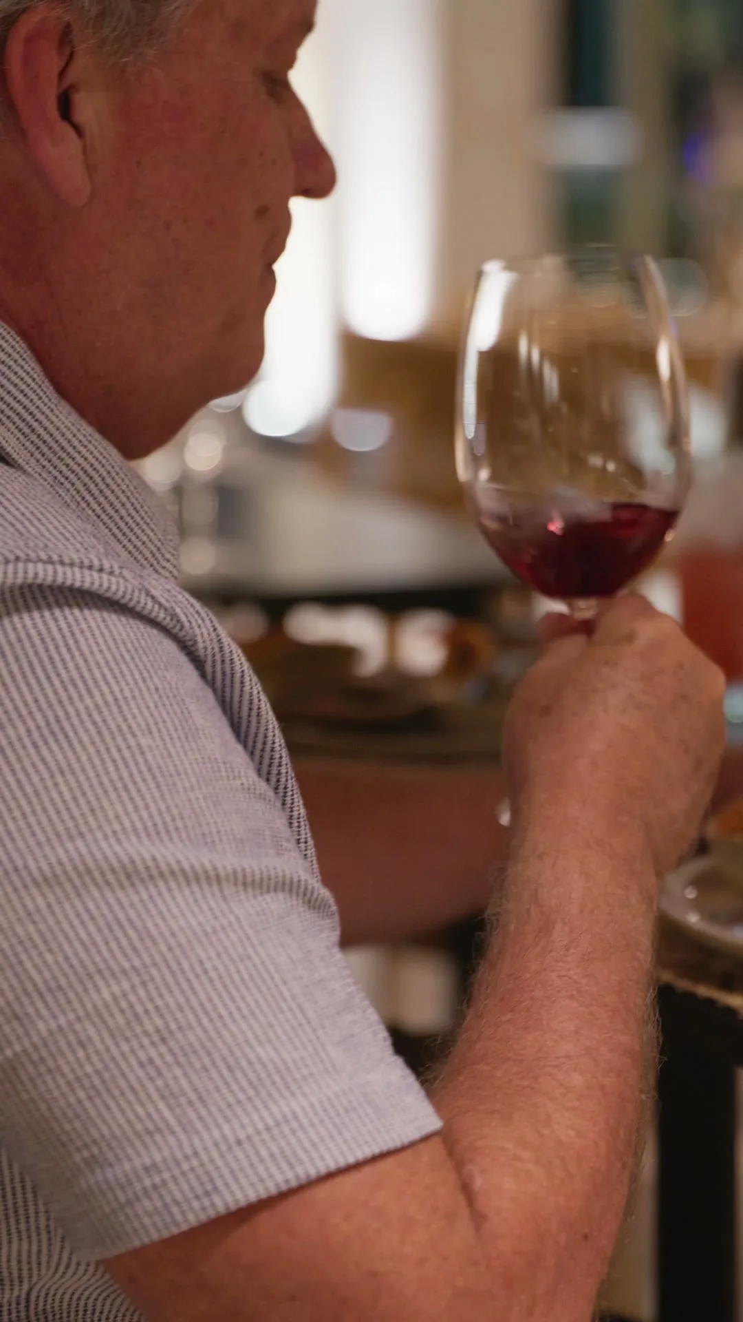 Hóspede em momento contemplativo com taça de vinho tinto